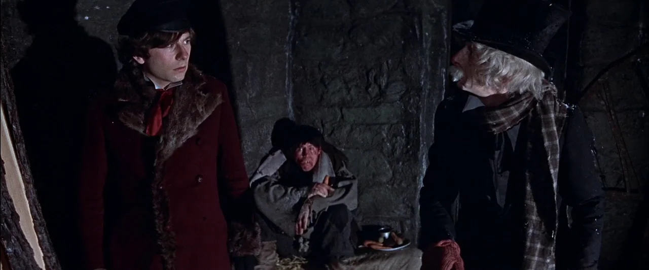 The Fearless Vampire Killers (1967) movie still: medium — A stone cellar with rough masonry walls and straw bedding on the floor. Two men in formal…