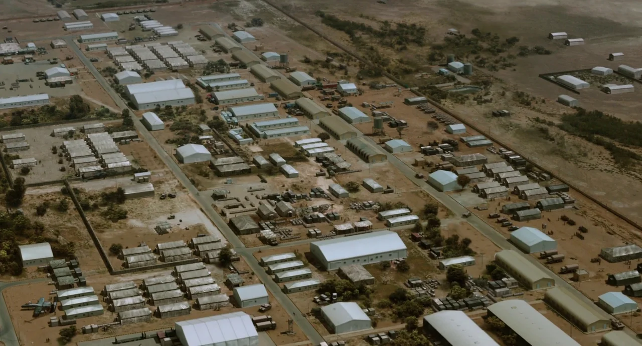 Zero Dark Thirty (2012) movie still: establishing — A vast military encampment features numerous rectangular buildings and barracks organized along…
