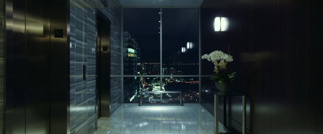 War Dogs (2016) movie still: establishing — A modern luxury elevator lobby with polished marble floors and dark wood paneled walls. A large…
