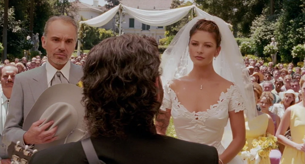 Intolerable Cruelty (2003) movie still: medium — An outdoor wedding takes place on a grassy lawn with a large white tent structure. A bride in a…