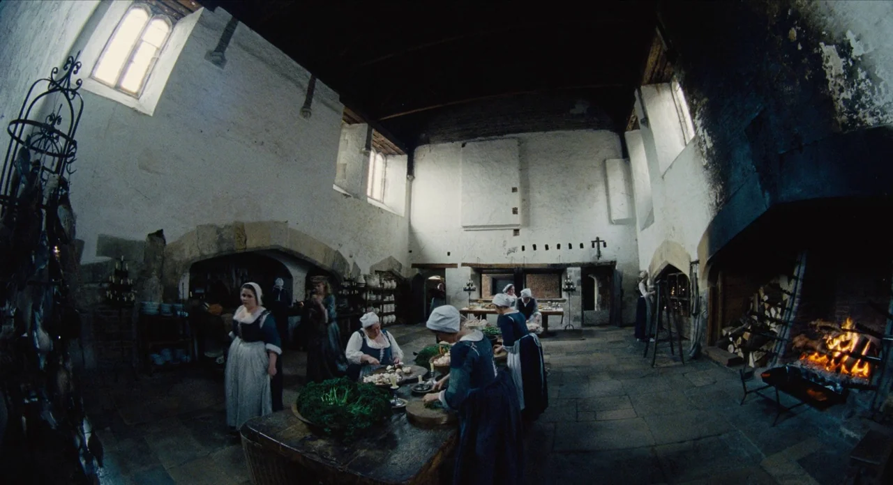 The Favourite (2018) movie still: wide — A spacious stone room features high ceilings with rough white walls and arched hearths. Women in period…