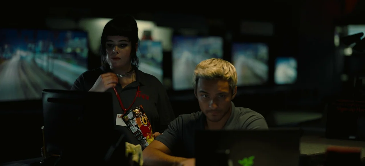 Nope (2022) movie still: medium — An electronics store at night filled with multiple screens displaying blurry content in darkness. A young woman…