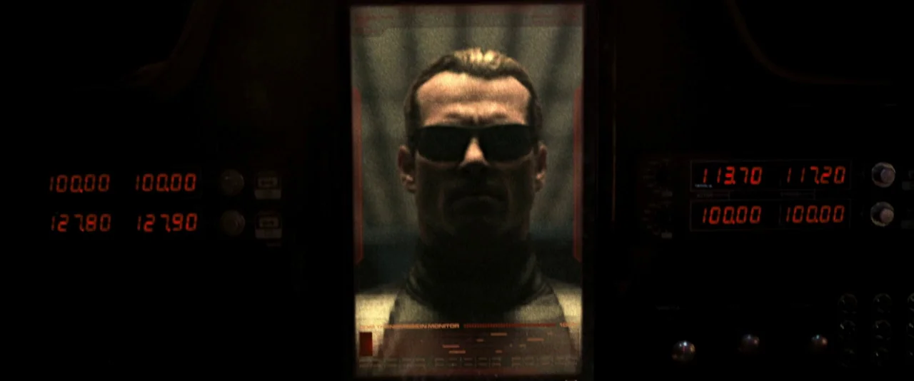 Resident Evil: The Final Chapter (2016) movie still: closeup — A dark dashboard with glowing red digital readouts frames a central vertical video…