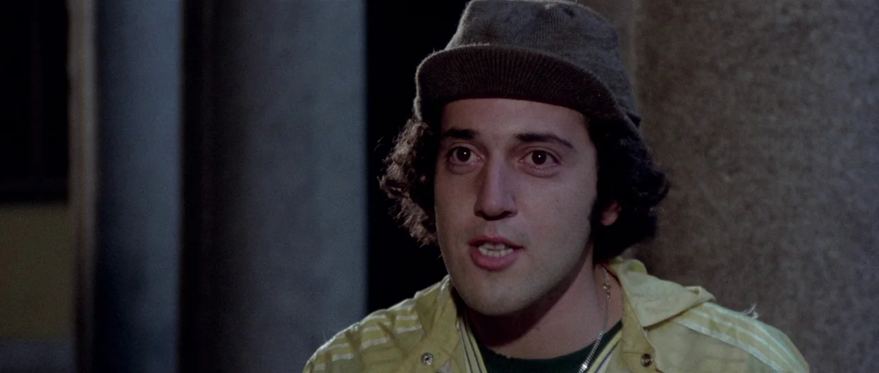 The Suspicious Death of a Minor (1975) movie still: closeup — A man stands in an outdoor urban setting at night. He is facing the camera and talking.