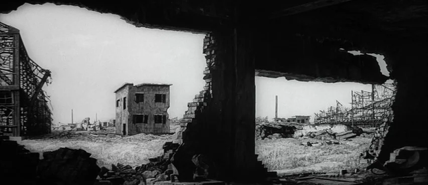 The Bad Sleep Well (1960) movie still: establishing — A vast, flattened landscape is filled with the wreckage of bombed industrial buildings. The…