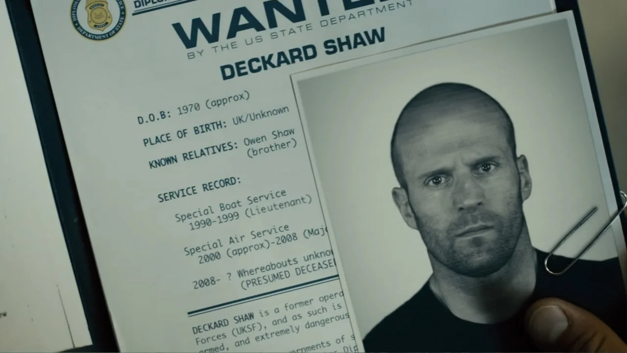 Furious 7 (2015) movie still: closeup — A close-up view of a government wanted poster featuring personal details of a subject. The document includes…