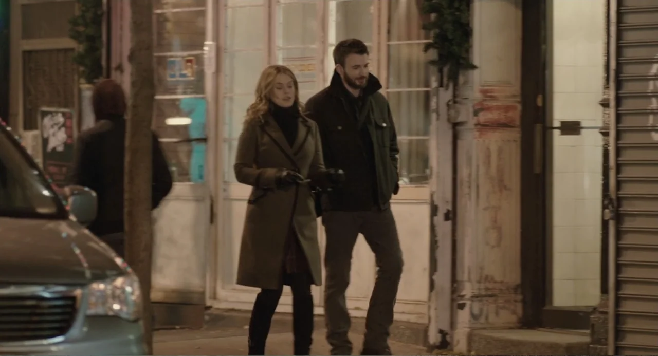 Before We Go (2014) movie still: fullbody — An urban sidewalk at night features a storefront with glass panes and metal shutters. A man and woman in…