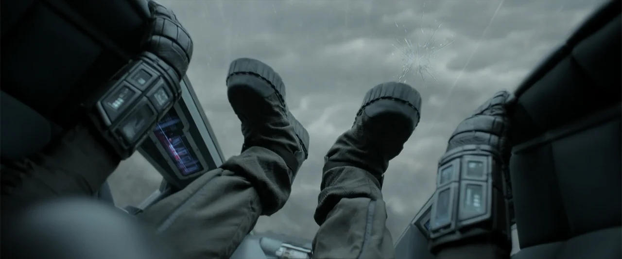 DISTANT (2026) movie still: closeup — The interior of a futuristic vehicle cockpit with a cracked glass observation window above. A pair of thick…