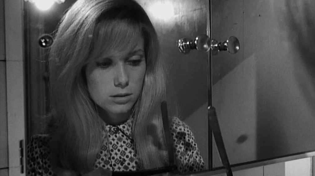 Repulsion (1965) movie still: closeup — A tiled interior bathroom features a wall-mounted mirrored medicine cabinet. A young woman views herself in…