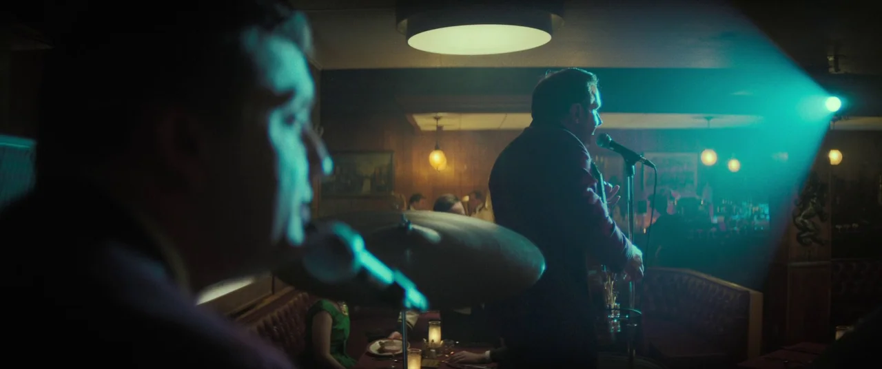The Many Saints of Newark (2021) movie still: medium — A dimly lit club features wood-paneled walls and red leather booths filled with patrons. A…
