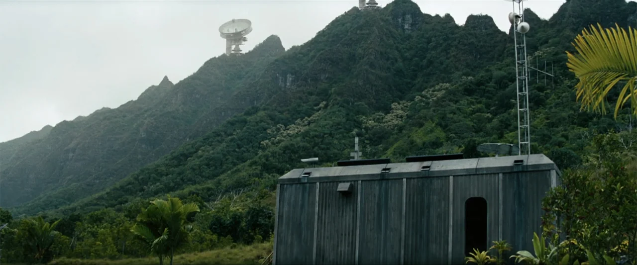 Battleship (2012) movie still: wide — A remote modular building sits at the base of a dense, forested tropical mountain. A large satellite dish…