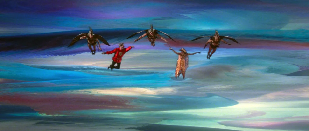 Flash Gordon (1980) movie still: wide — A surreal, dreamlike environment features sweeping, painted swirls of blue and purple mist. Five people…