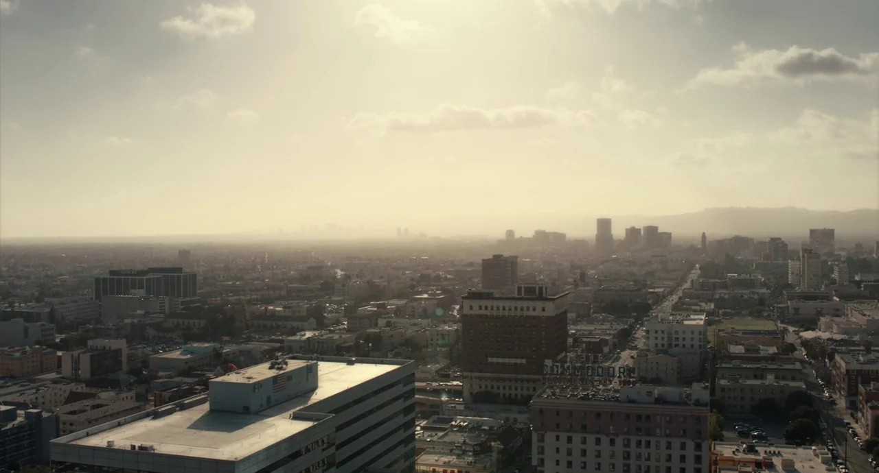 Roman J. Israel, Esq. (2017) movie still: establishing — A sprawling urban cityscape viewed from above with a hazy, light-drenched atmosphere. Rows…