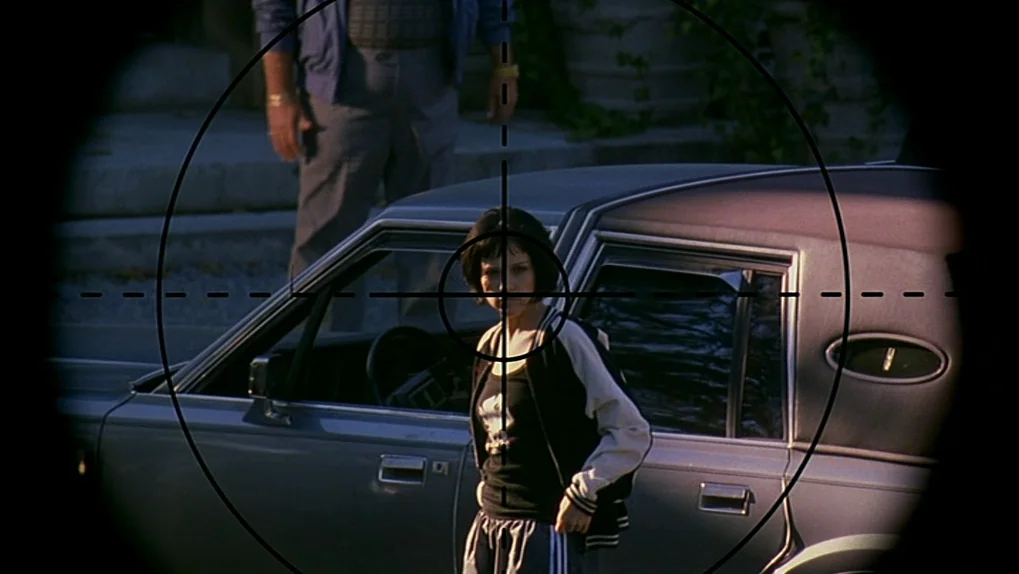 Ghost Dog: The Way of the Samurai (1999) movie still: medium — A suburban residential area with a parked silver sedan and a partially visible man.…