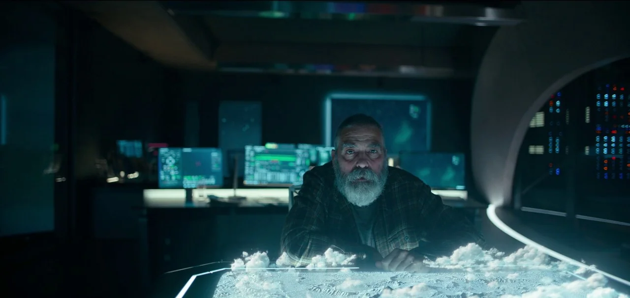 The Midnight Sky (2020) movie still: medium — A dark, high-tech command center features glowing computer displays and a large table console. An…