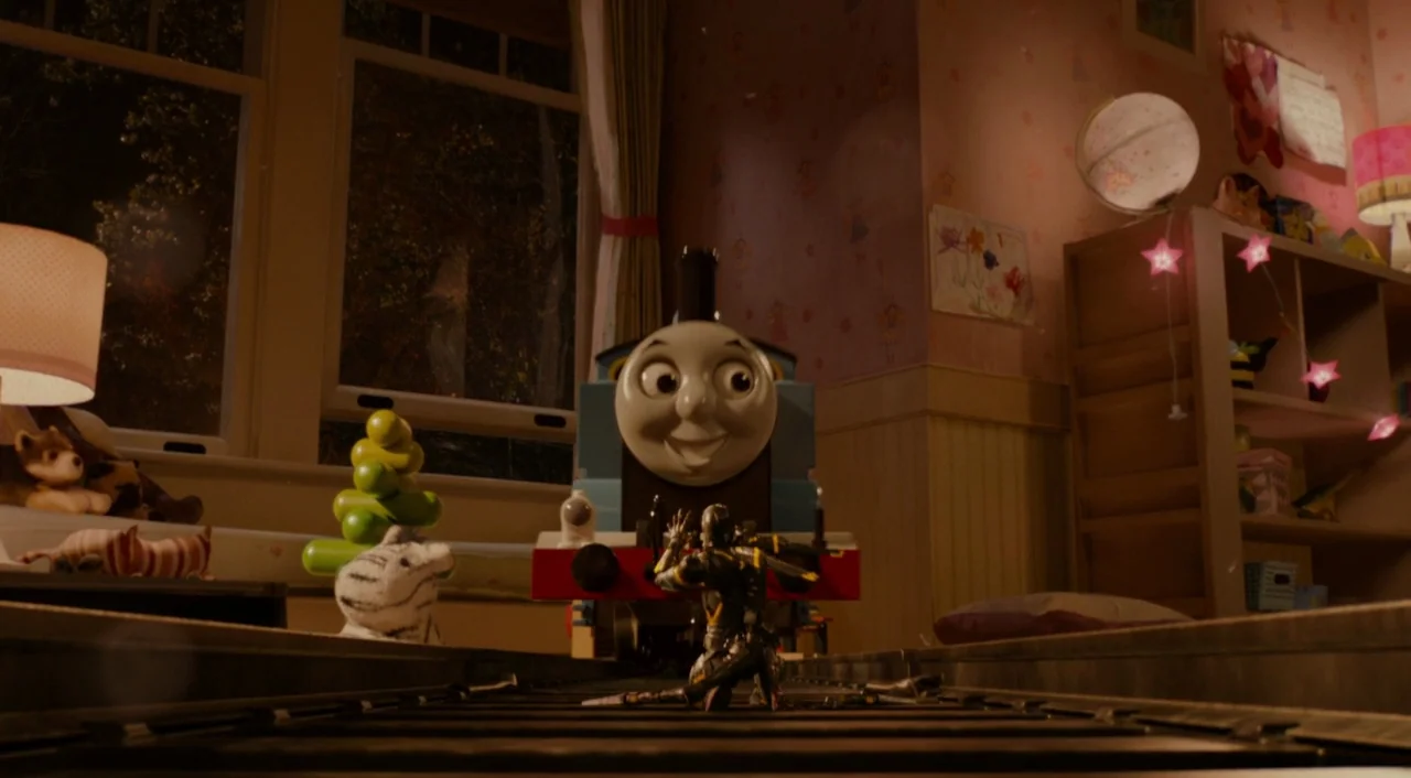 Ant-Man (2015) movie still: medium — A dimly lit child's room features a large toy train engine centered on tracks. A small armored soldier figure…