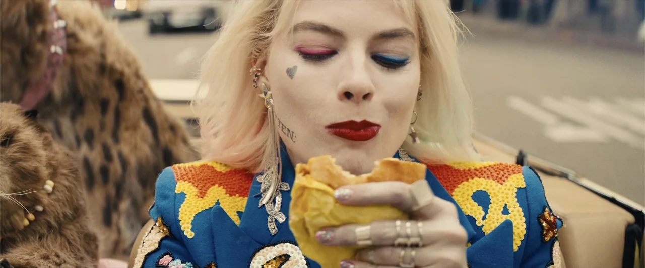Birds of Prey (and the Fantabulous Emancipation of One Harley Quinn) (2020) movie still: closeup — A woman stands outdoors on a blurred city street…