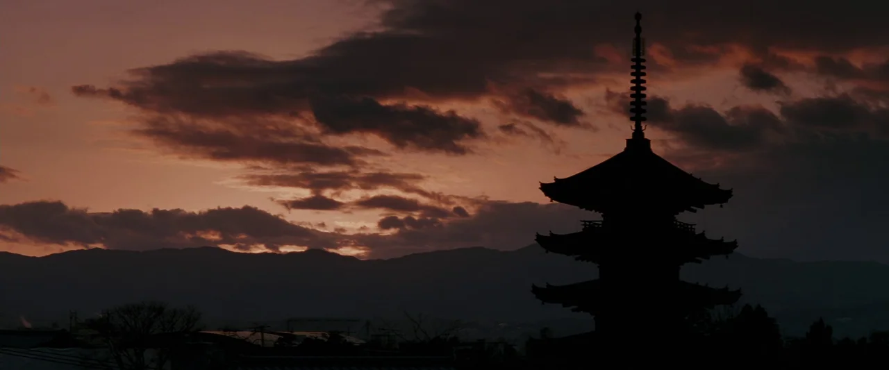Memoirs of a Geisha (2005) movie still: establishing — A traditional Japanese pagoda stands in silhouette against a dramatic, cloudy sunset sky.…