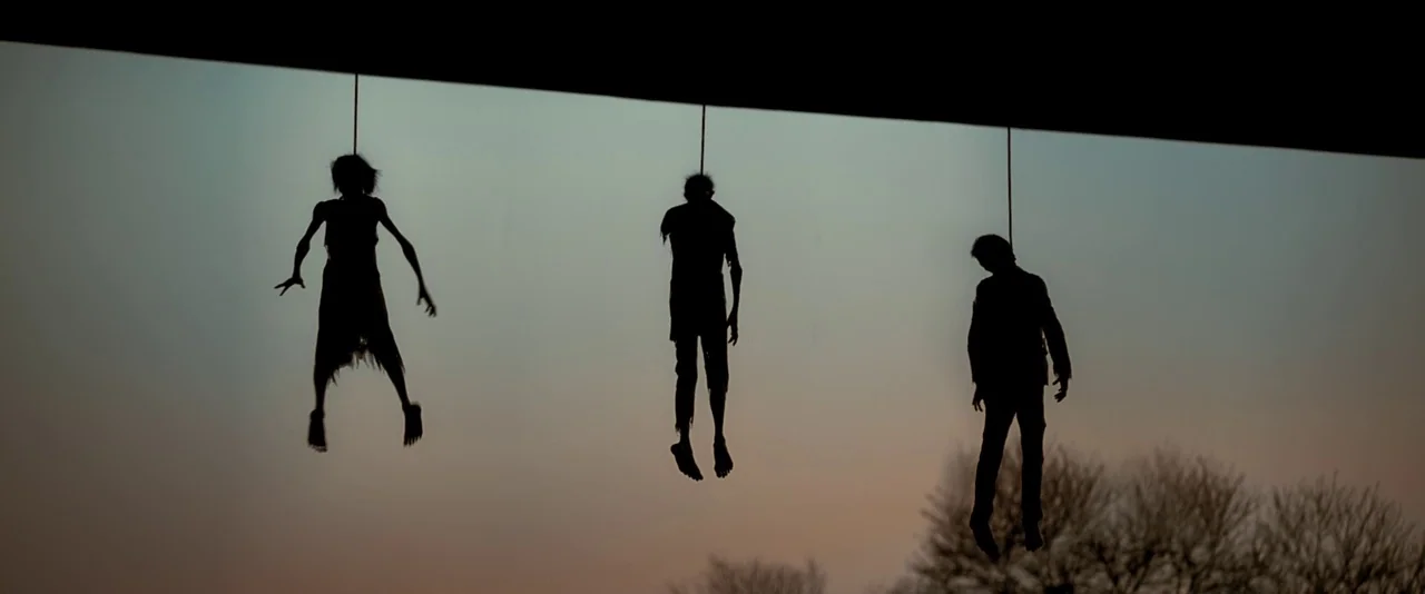 Resident Evil: The Final Chapter (2016) movie still: A haunting, minimalist wide shot capturing three silhouetted figures suspended in the twilight.…
