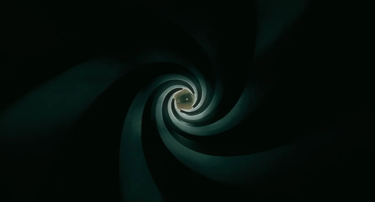 Uzumaki (2000) movie still: closeup — A dark spiral of rifling forms the interior view of a gun barrel. A human eye stares directly through the…