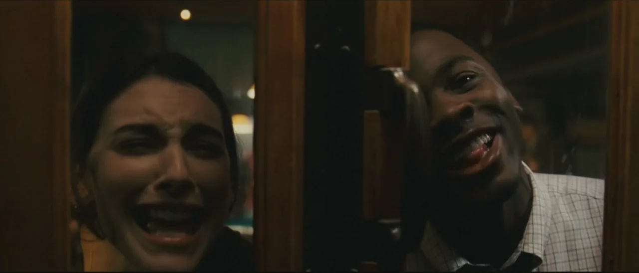 Definitely, Maybe (2008) movie still: medium — Two people are positioned behind a dark wooden framed glass door in a dim room. The woman on the left…