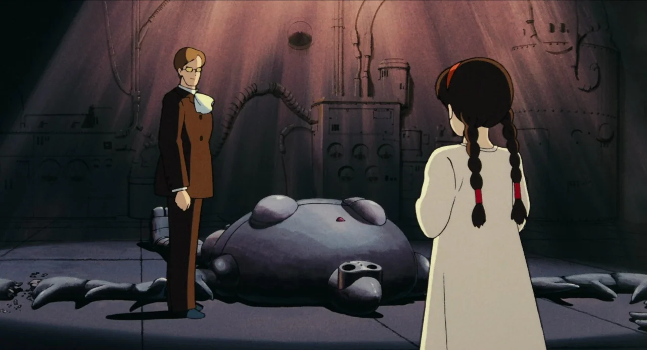 Castle in the Sky (1986) movie still: medium — An industrial space with exposed pipes and metallic surfaces illuminated by overhead light shafts. A…