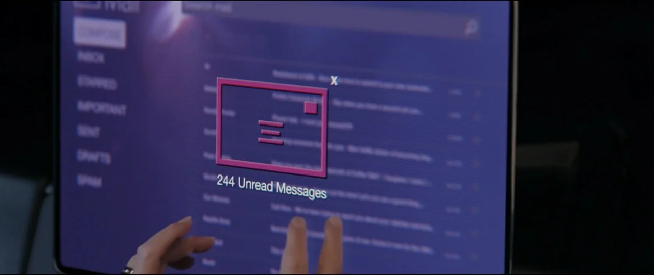 Summer Camp (2024) movie still: closeup — A dark room displays a glowing digital mail interface with a large pink icon. Human hands reach toward the…