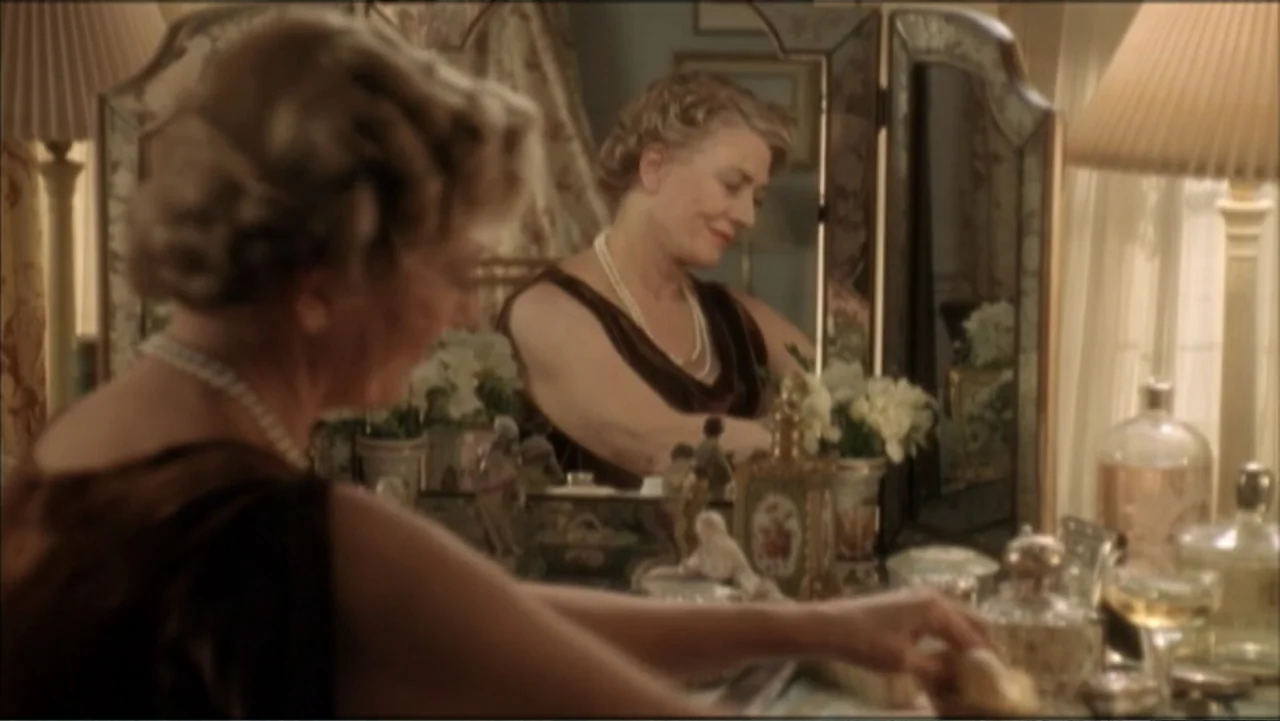 The Gathering Storm (2002) movie still: medium — A well-lit bedroom features a vanity table with a tri-fold mirror and perfume bottles. An elderly…