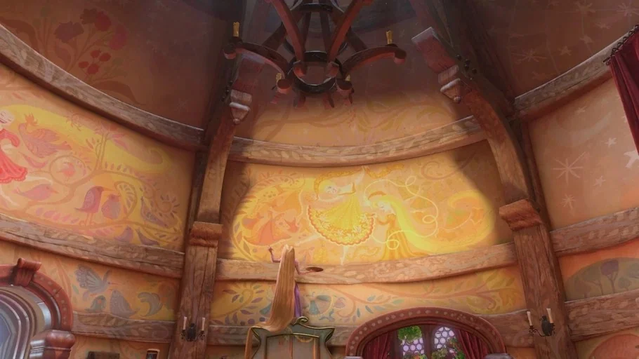 Tangled (2010) movie still: wide — The interior of a tall cylindrical tower features walls covered in ornate painted murals. A young woman stands on…