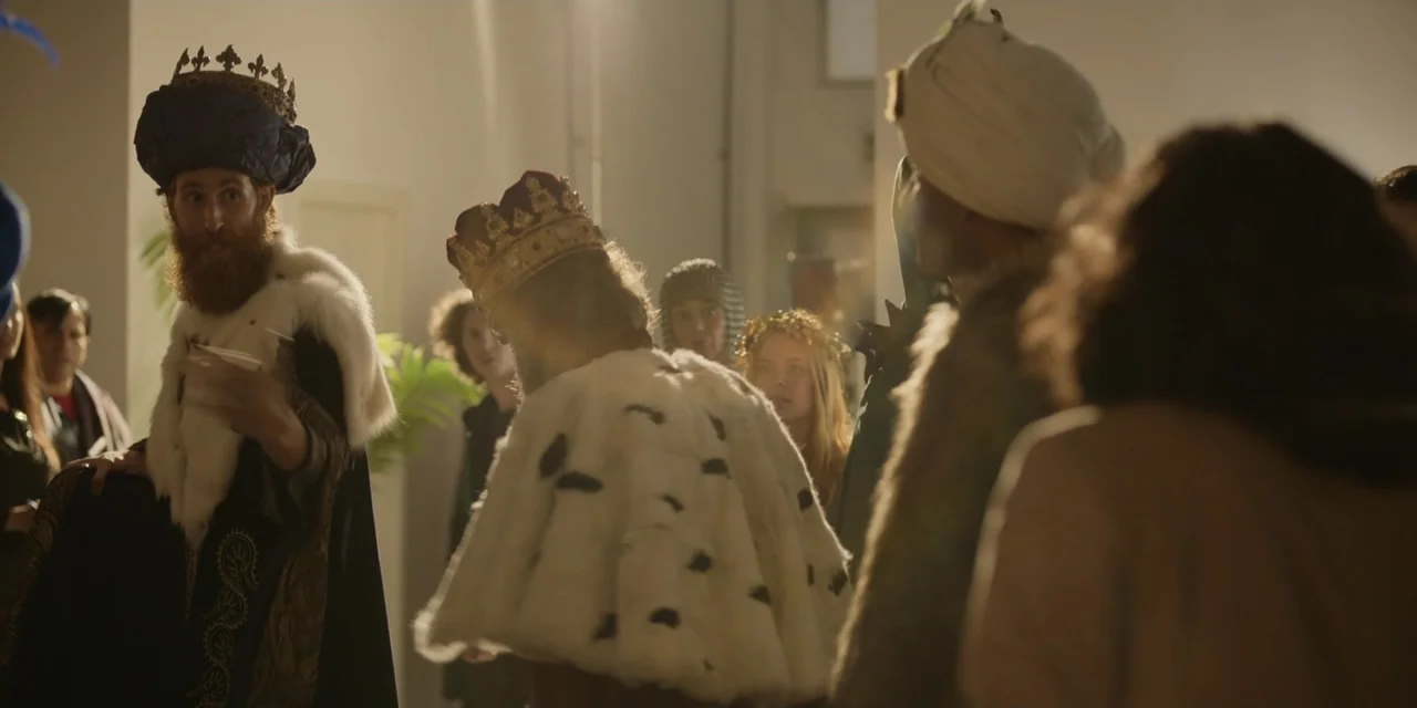 The Three Wise Men: The Truth (2022) movie still: medium — A group of people wearing theatrical costumes stands together in a bright, modern indoor…