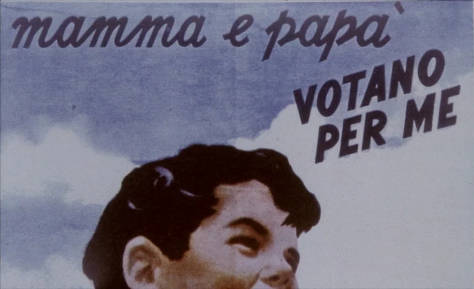 The Kingdom of Naples (1978) movie still: closeup — A close-up shot of a political poster featuring an illustration of a young boy. The printed text…