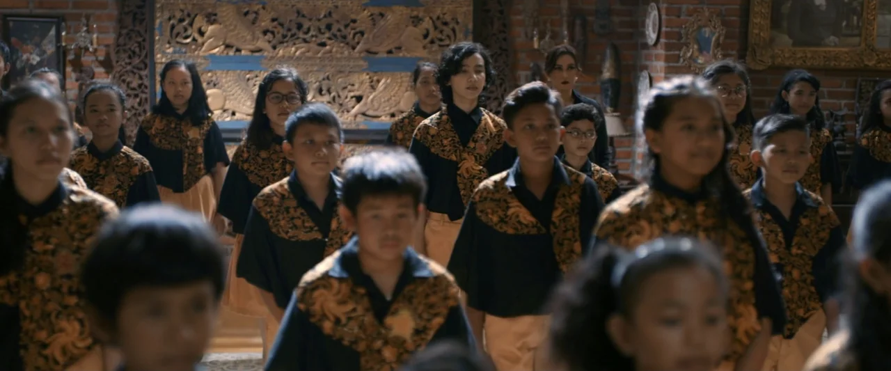 The Chanting 3 (2008) movie still: medium — A spacious room features exposed brick walls decorated with large ornate wooden wall hangings. A large…