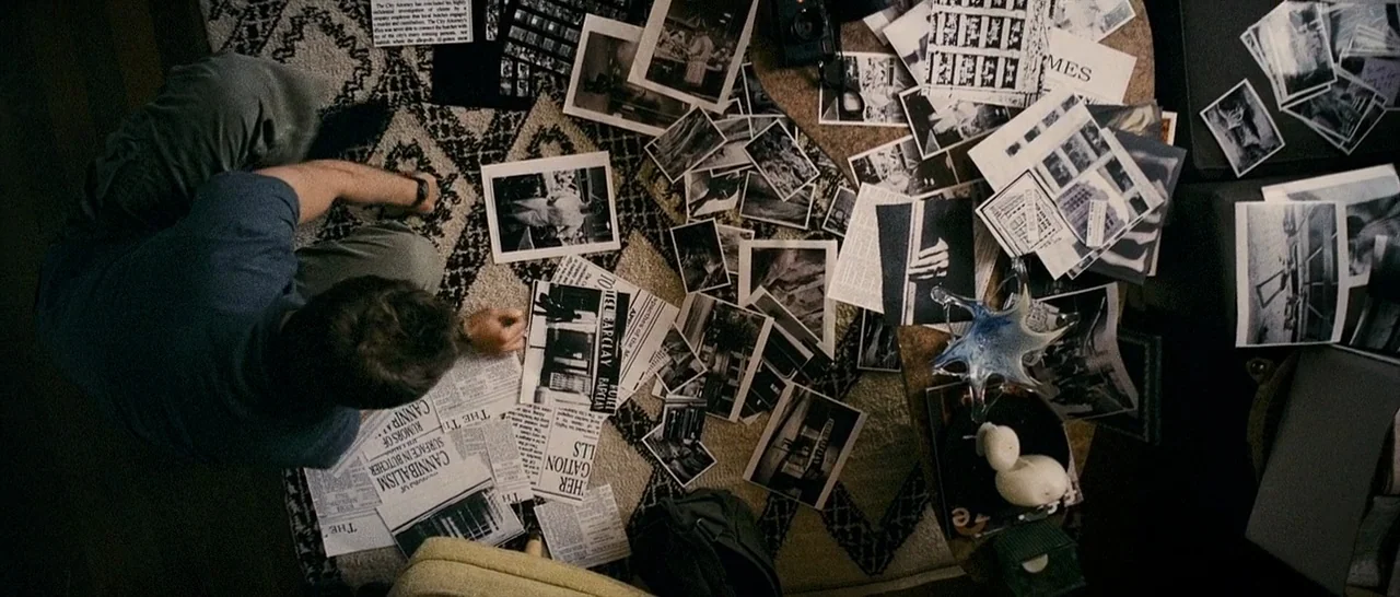 The Midnight Meat Train (2008) movie still: wide — A dark, carpeted floor is cluttered with black-and-white crime scene photos and newspaper…