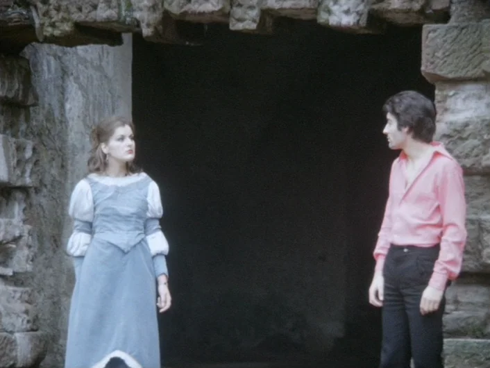 Eika Katappa (1969) movie still: fullbody — An ancient stone archway provides a dark entrance behind a woman and a man. The man stands on the right…