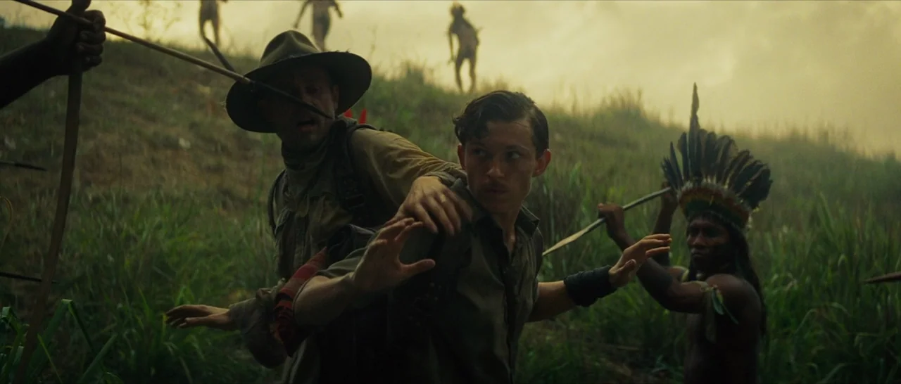 The Lost City of Z (2016) movie still: medium — A grassy, mist-covered hillside in a remote tropical region during the early twentieth century. Two…