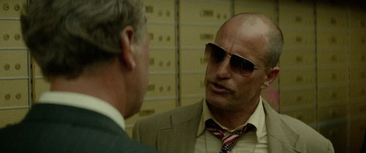Triple 9 (2016) movie still: medium — An interior space features walls lined with numerous numbered metal safe deposit boxes. A man wearing…