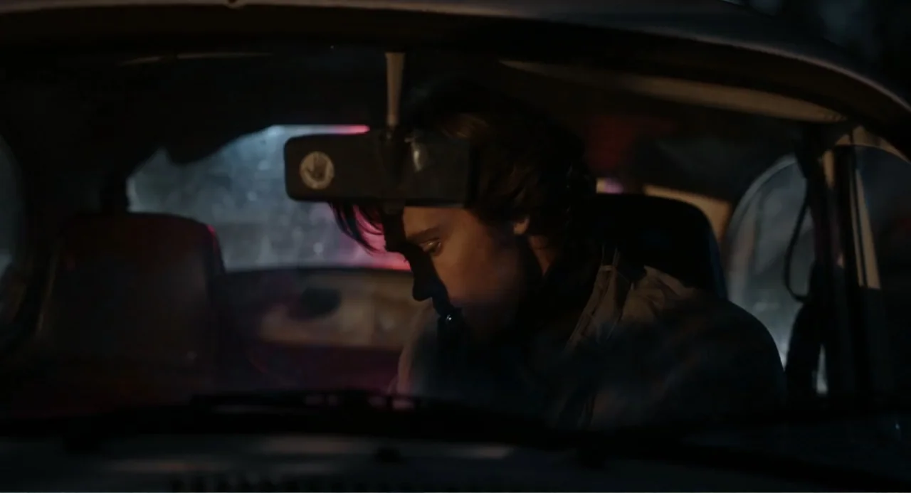 Ted Bundy: American Boogeyman (2021) movie still: medium — The interior of a moving vehicle at night with dark surroundings. A young man wearing a…