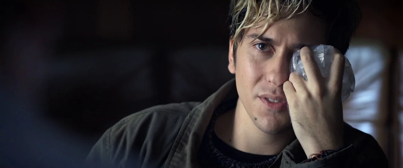 Death Note (2017) movie still: closeup — A man sits in a dimly lit room with walls visible in the blurred background. He holds a clear plastic bag…