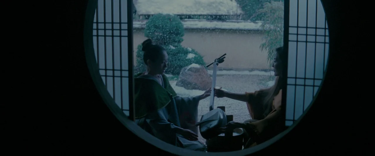 Memoirs of a Geisha (2005) movie still: medium — A traditional room features a circular architectural cutout looking out onto a snowy garden. Two…