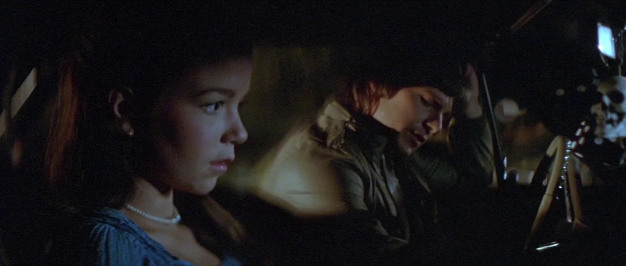 The Funhouse (1981) movie still: medium — The interior of a car at night with two people sitting in the front seats. A woman looks straight ahead…
