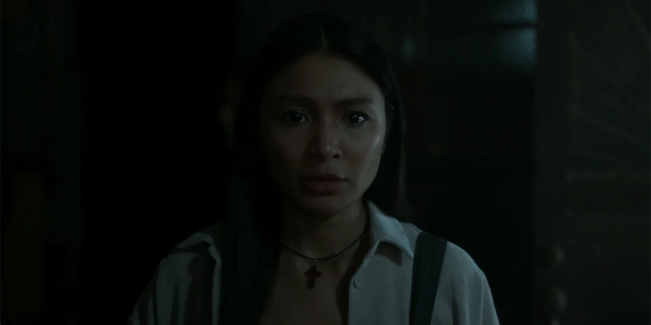 Nokturno (2024) movie still: closeup — A dark indoor space with minimal ambient light obscuring the structural background details. A young woman…