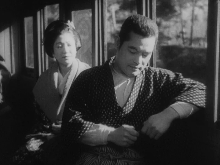 Sanshiro Sugata (1943) movie still: medium — Inside a wood-paneled passenger car, a man and woman sit next to a window. The exterior landscape is…