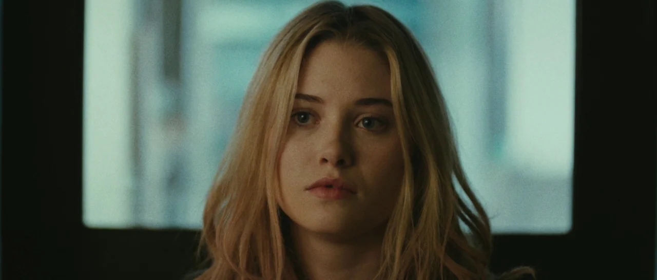 Starfish (2018) movie still: closeup — A woman stands in an office with a window in the background. She faces forward.