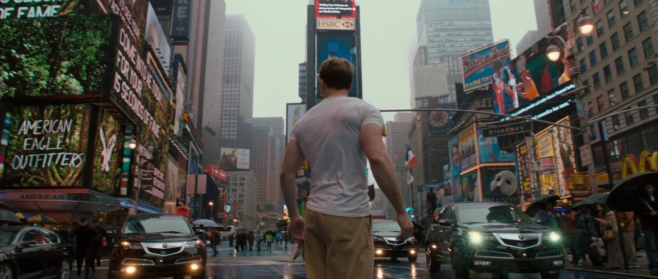 Captain America: The First Avenger (2011) movie still: fullbody — A man stands in the middle of a crowded, rain-slicked Times Square intersection.…
