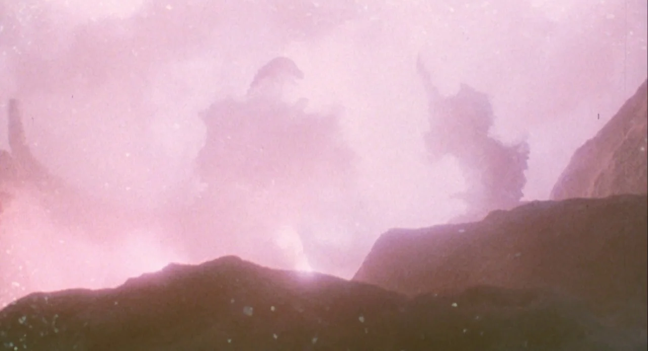 Godzilla and Mothra: The Battle for Earth (1992) movie still: establishing — A rocky, jagged volcanic landscape is obscured by heavy, thick plumes…