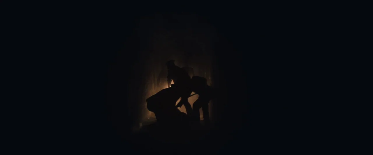 The Immigrant (2013) movie still: wide — A dark, cavernous opening creates a portal against a pitch-black background. Three shadowy figures stand…