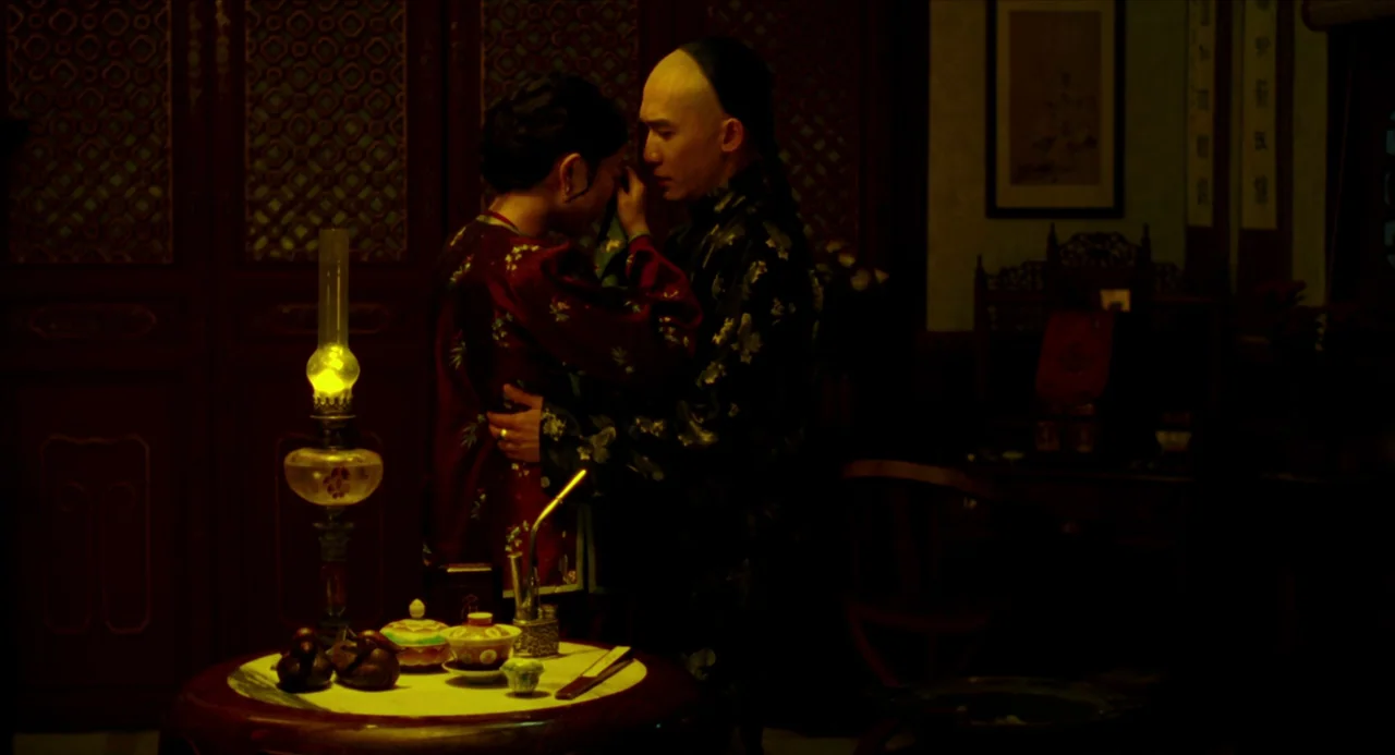 Flowers of Shanghai (1998) movie still: medium — A dim room features ornate dark wood paneling and traditional Chinese decor in low light. A man and…