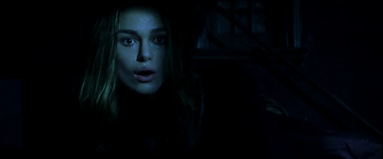 Pirates of the Caribbean: The Curse of the Black Pearl movie still: A high-tension close-up of a young woman reacting to something unseen in the…