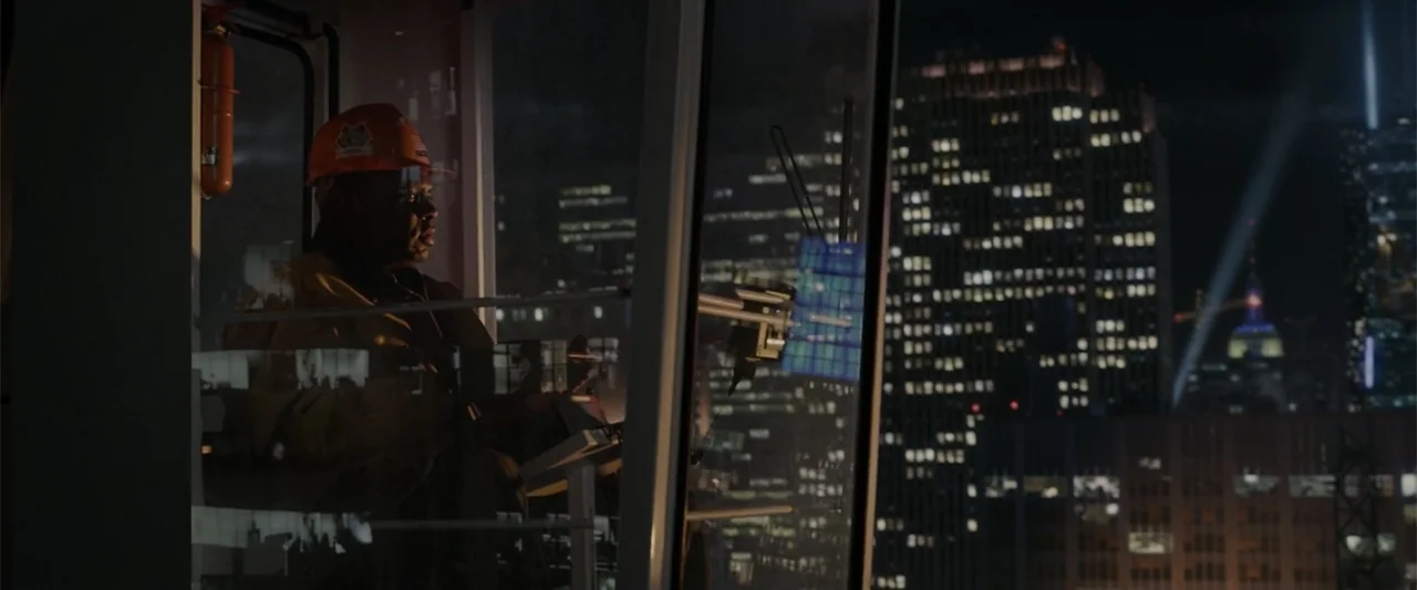 The Amazing Spider-Man (2012) movie still: medium — A high-altitude crane cabin at night overlooks a dense urban skyline with lit buildings. A man…