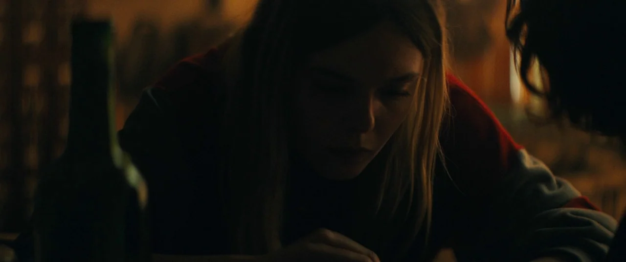 I Think We’re Alone Now (2018) movie still: An intimate medium-closeup captures a young woman looking downward in quiet contemplation, her face…
